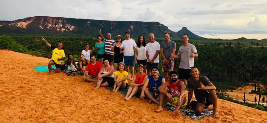 Dunas do Jalapão - Foto do grupo de amigos nas areias que vão mudando em tons dourados tendo ao fundo a vista da Serra do Espírito Santo.